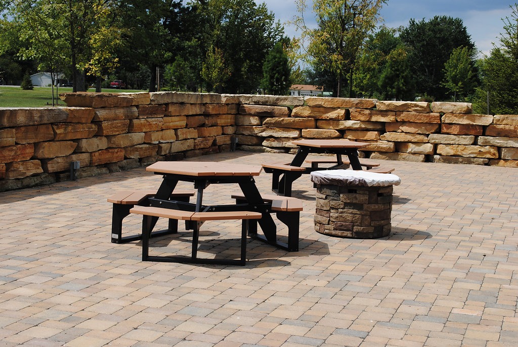 Stone patio with picnic tables and fire pit.