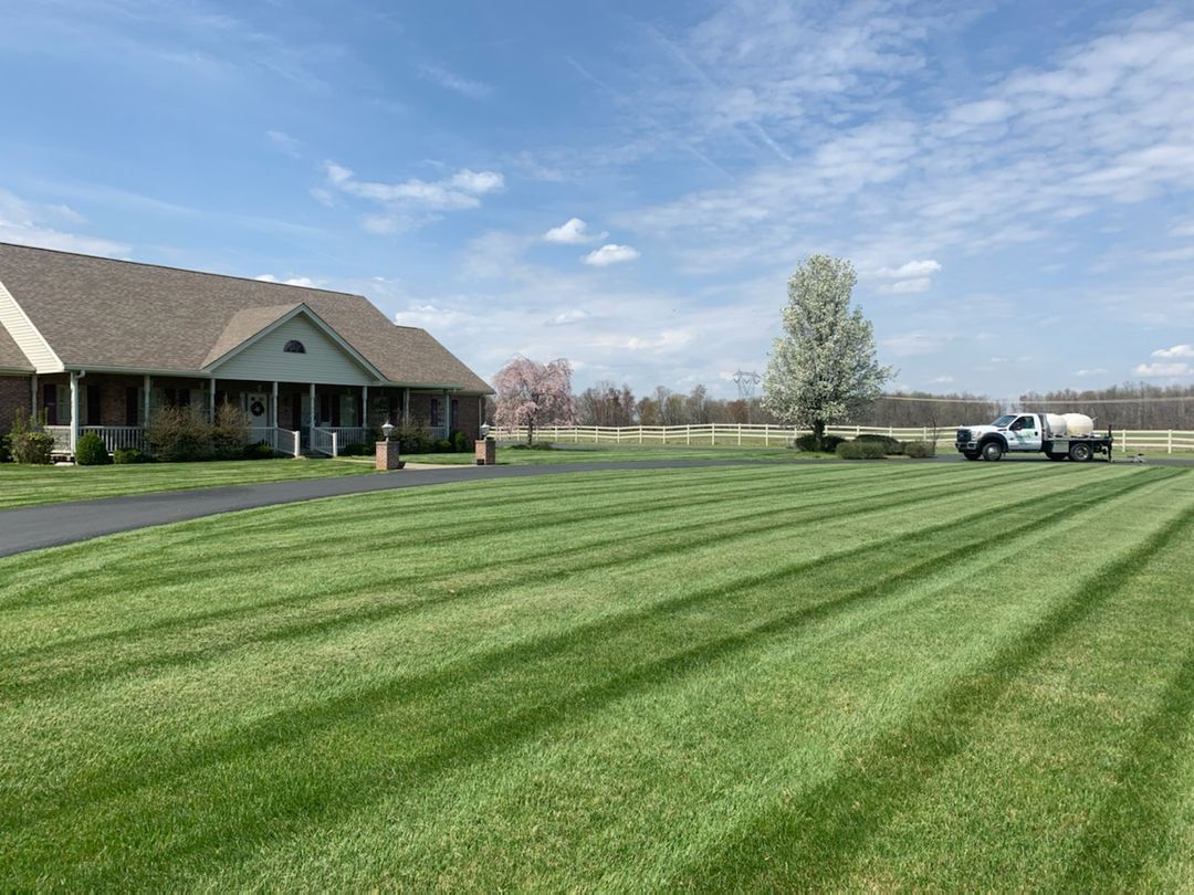 Lawn care truck on residential property with green grass.