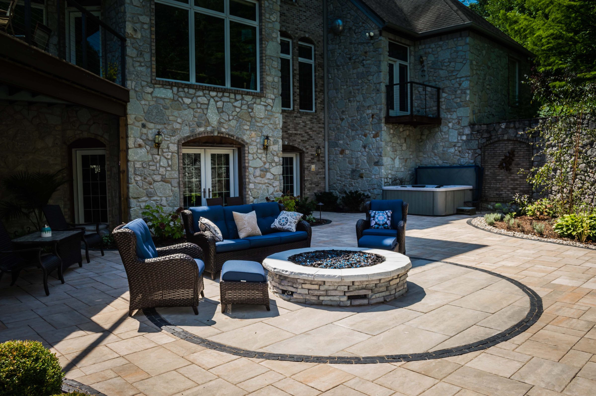 Stone patio with fire pit and seating area.