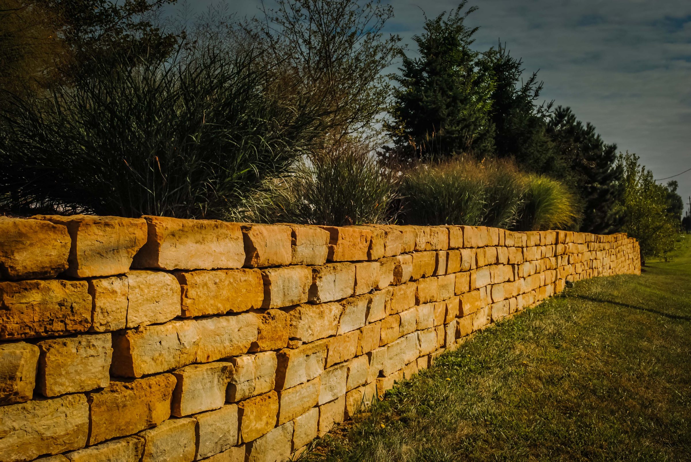 Stone retaining wall with greenery backdrop