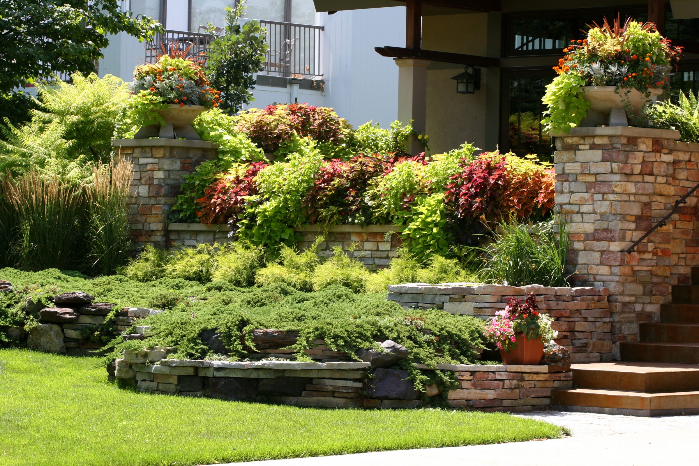 Vibrant garden with stone planters and greenery.
