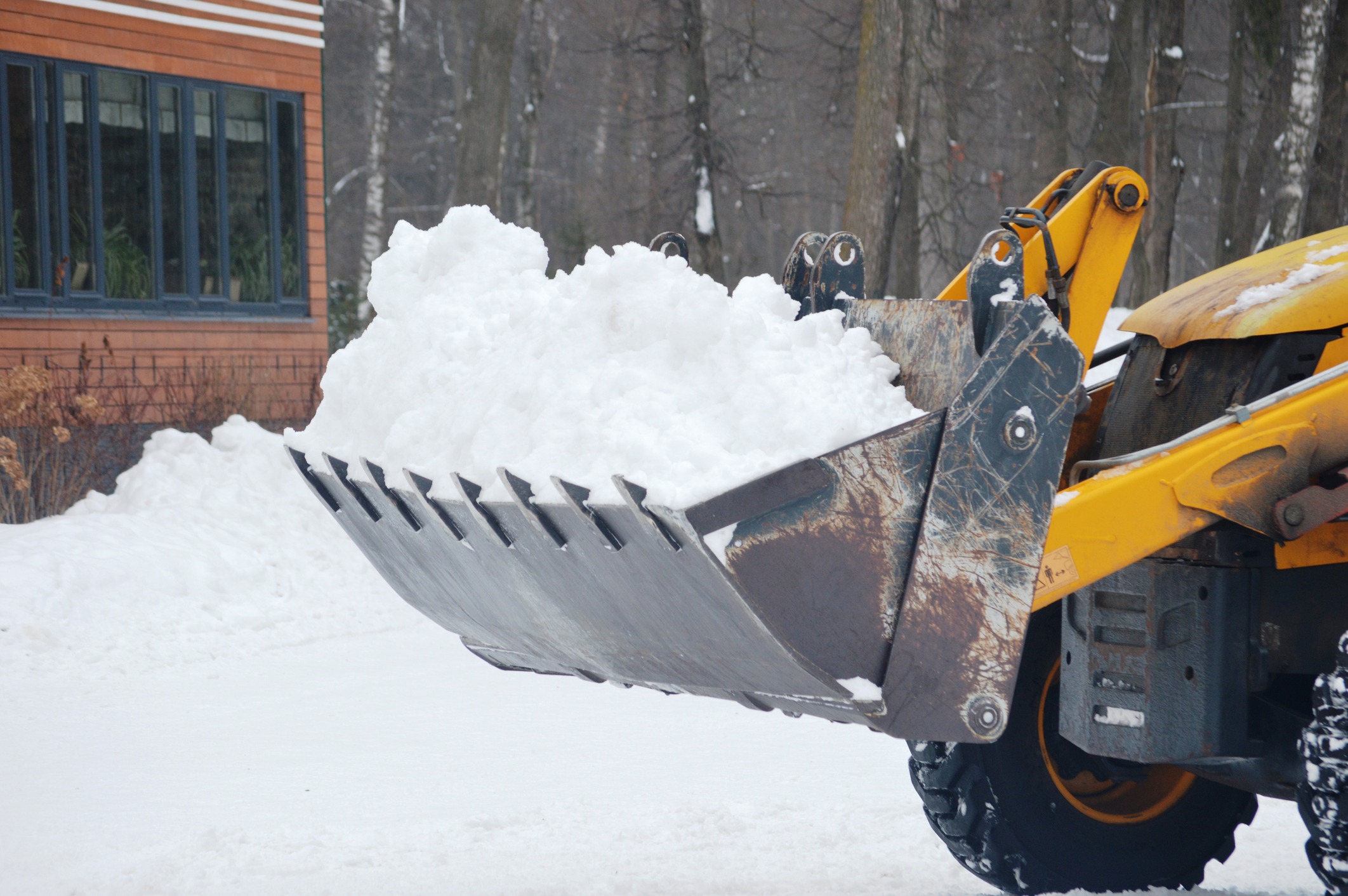 Bulldozer clearing snow from a driveway.