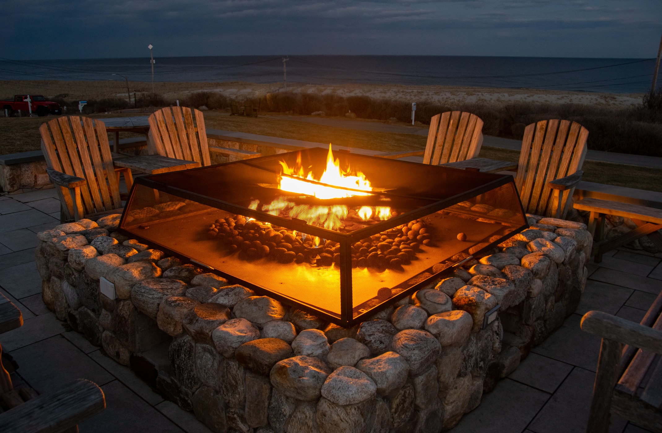 Outdoor stone fire pit by the ocean at sunset.