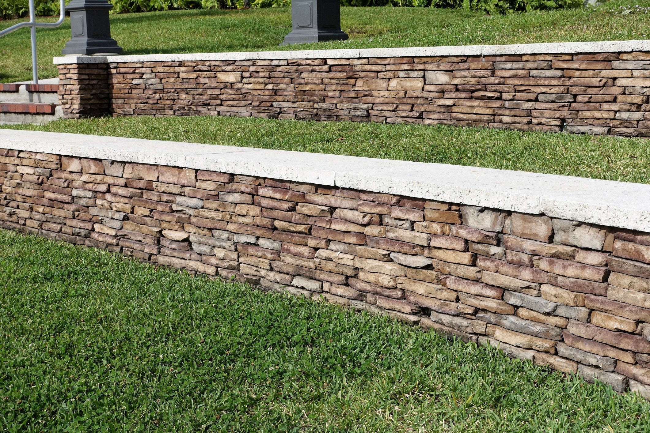 Stone retaining wall with grass and steps