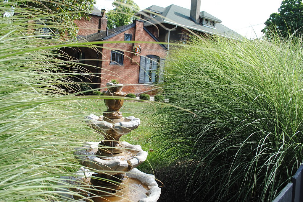 Brick house with garden fountain and greenery